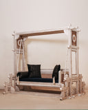 Front view of swing, handmade in Lahore, styled with cushions in a cozy indoor setting.