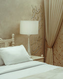 Elegant table lamp placed beside the bed, adding functional light and a soft decorative touch to the room.