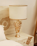 Lamp glowing softly next to jhoomer bed set, creating a relaxing bedroom feel.