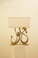 Softly illuminated, the Junoon Calligraphy Lamp showcases exquisite handcrafted design and elegant calligraphy, enhancing the ambiance of a luxurious living room.