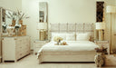 Full view of bed set in a well-lit room with layered pillows and decorative cushions.
