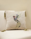 Decorative pillow with a hummingbird design on a beige couch.