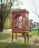 Decorative birdcage with birds on a stand in an outdoor setting