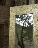 Close-up of a brass-framed mirror with a clean, elegant finish.