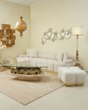 Modern living room with a beige sectional sofa, glass coffee table, and decorative wall mirrors.