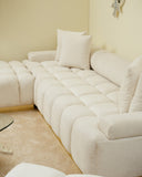 White sectional sofa with cushions in a living room setting.