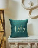 Teal pillow with dada text on a decorative table