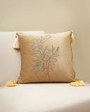 Decorative pillow with floral embroidery and tassels on a beige background