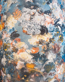 A close-up of a fabric or wallpaper pattern featuring an abstract, painterly floral design in muted blue, cream, orange, gray, and black tones.