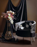 A beautifully designed chair adds charm to an elegant interior setting, styled with timeless decor accents.

