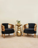 two golden & black chairs with a sid table. 