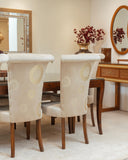 Dining room with beige chairs, wooden table, and decorative elements.