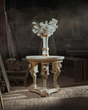 Decorative table with a vase of white flowers in a dark, industrial setting