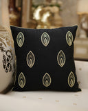 Black pillow with gold patterns on a white couch