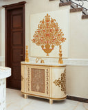 An ornate cream and gold console cabinet in a luxurious interior setting, featuring a large matching gold and orange decorative wall art piece above it.