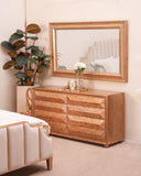 Wooden dresser with mirror in a bedroom setting