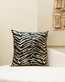 Tiger print pillow on a white sofa with a beige wall in the background