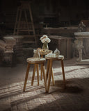 Three wooden stools with decorative items in a rustic setting