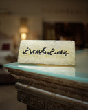 Decorative stone with urdu calligraphy on a reflective surface