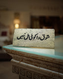 Decorative sign with urdu text on a reflective surface