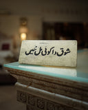 Decorative sign with urdu calligraphy on a reflective surface