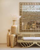 Decorative vases and a mirror with Arabic text in a room setting.